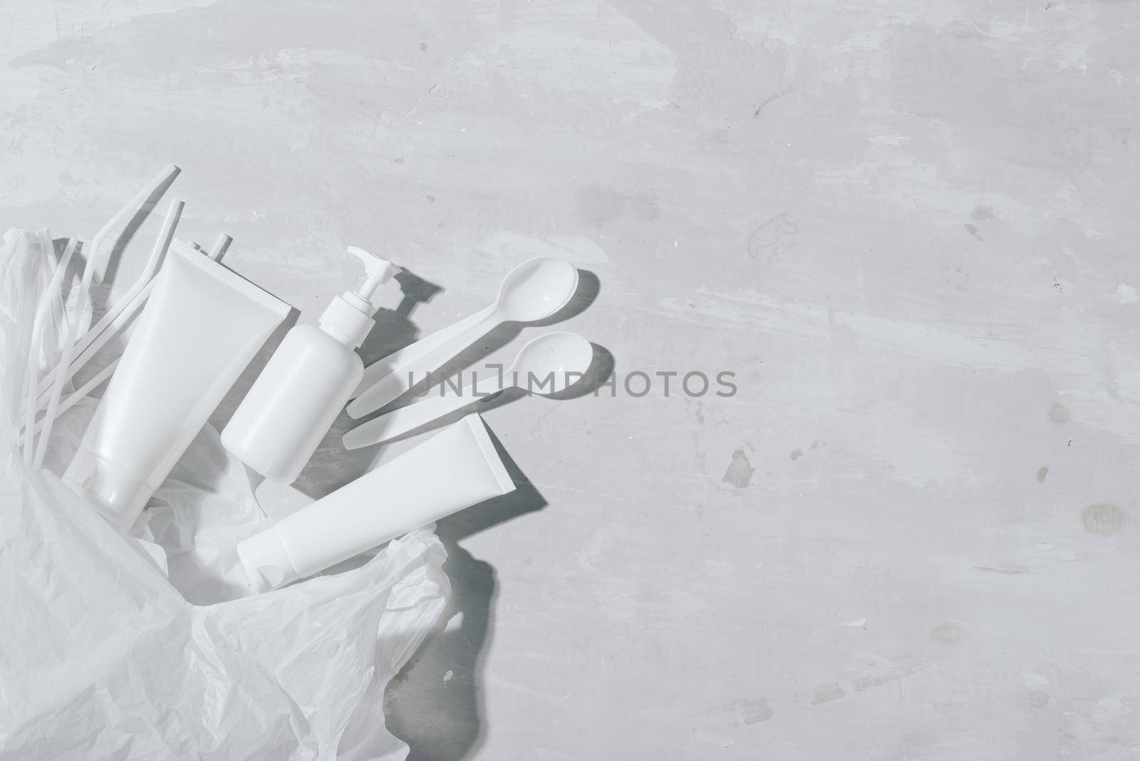 No plastic recycle concept white plastic dishes plates cups spoon on stone background. Copy space. Top view by makidotvn