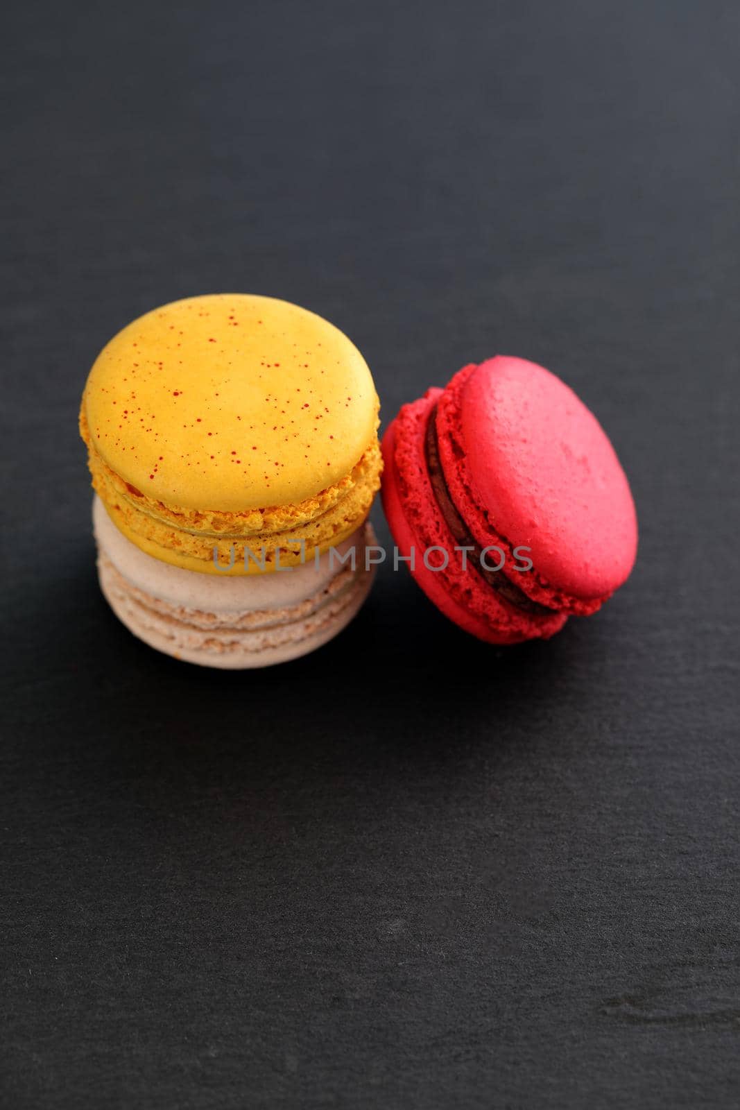 Colorful macarons isolated in black background by piyato