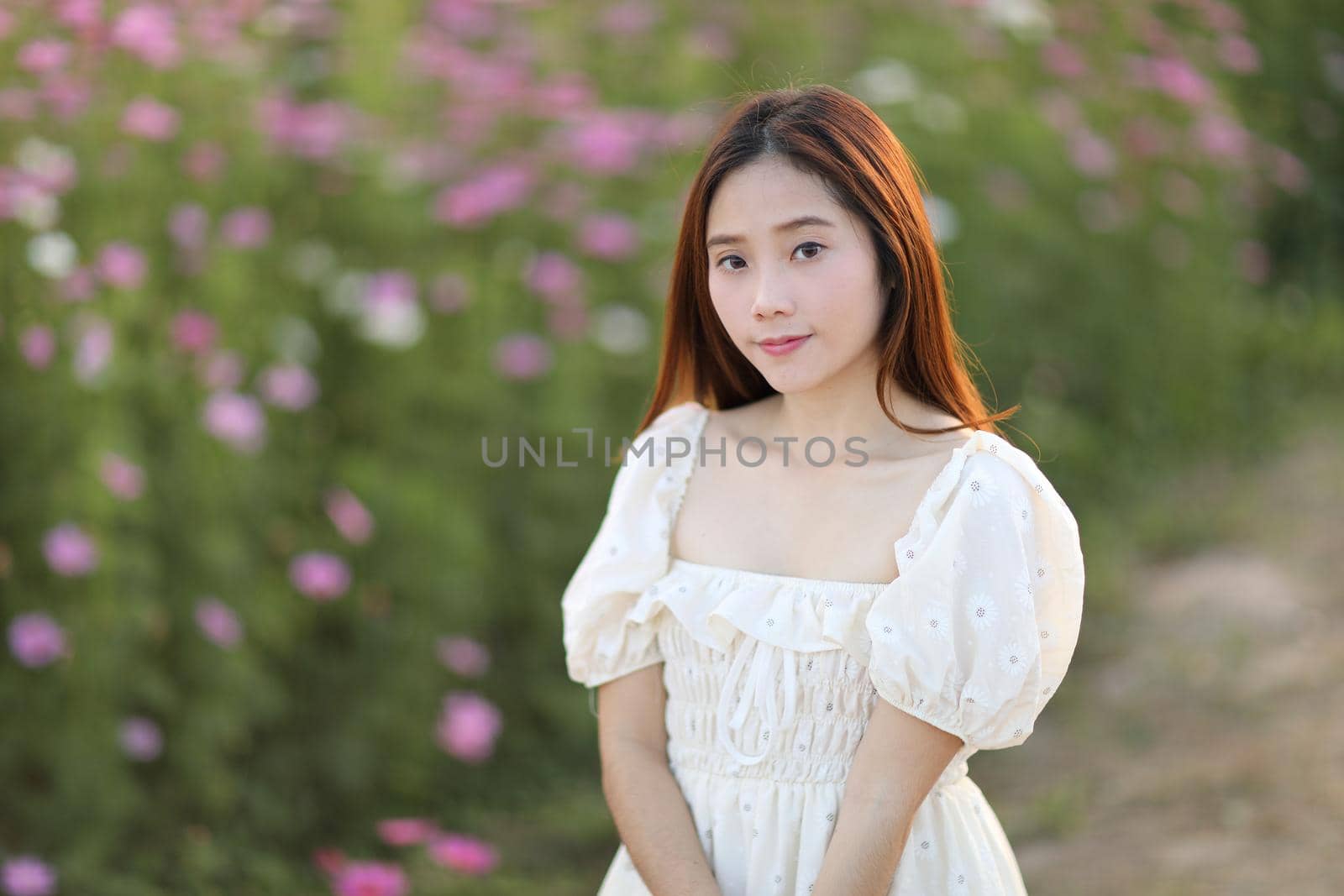 Beautiful young woman with white dress on garden background by piyato