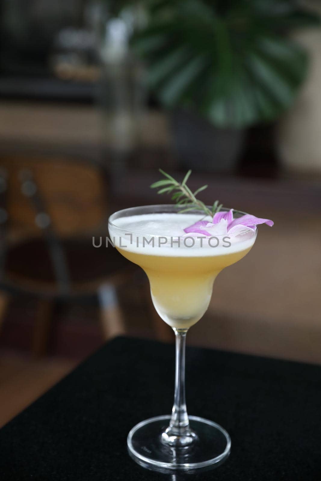 Pink Cocktail glass with ice at a bar counter by piyato