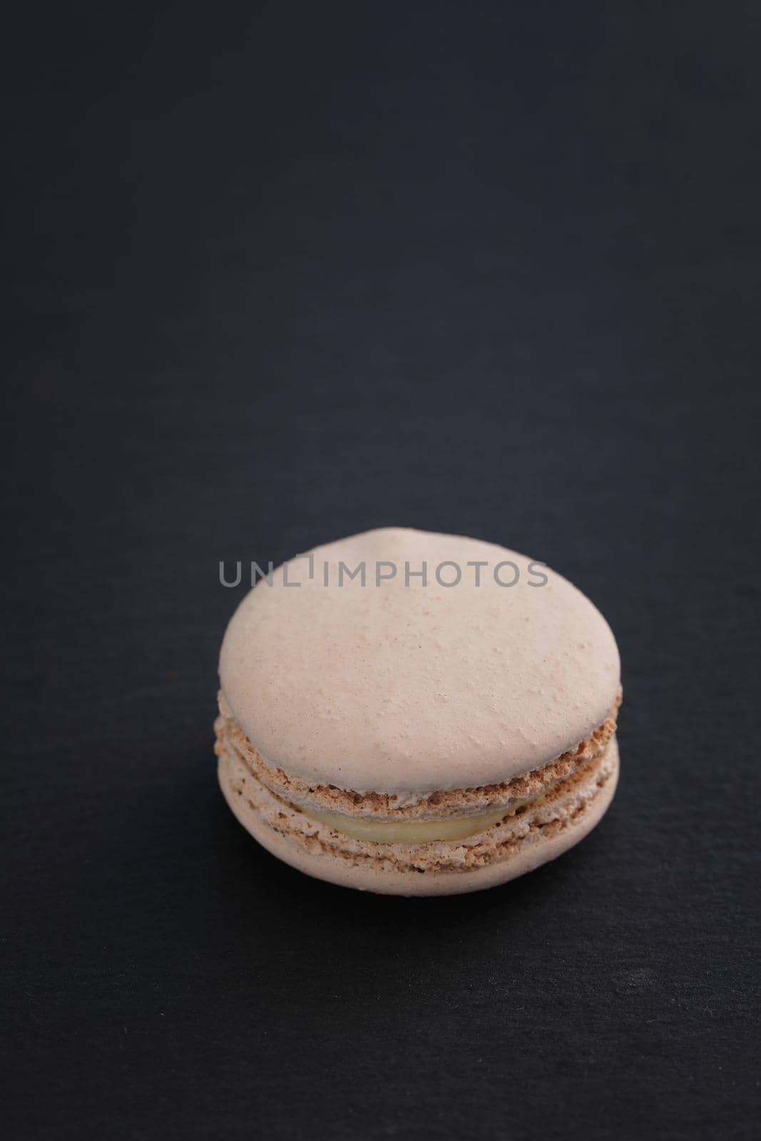 Colorful macarons isolated in black background by piyato