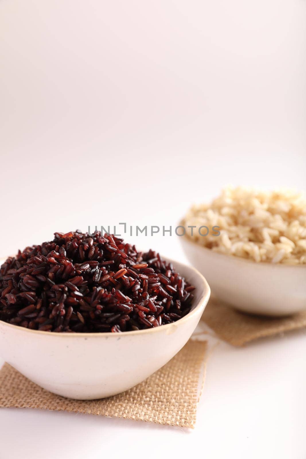Organic boiled brown rice on bowl isolated in white background by piyato