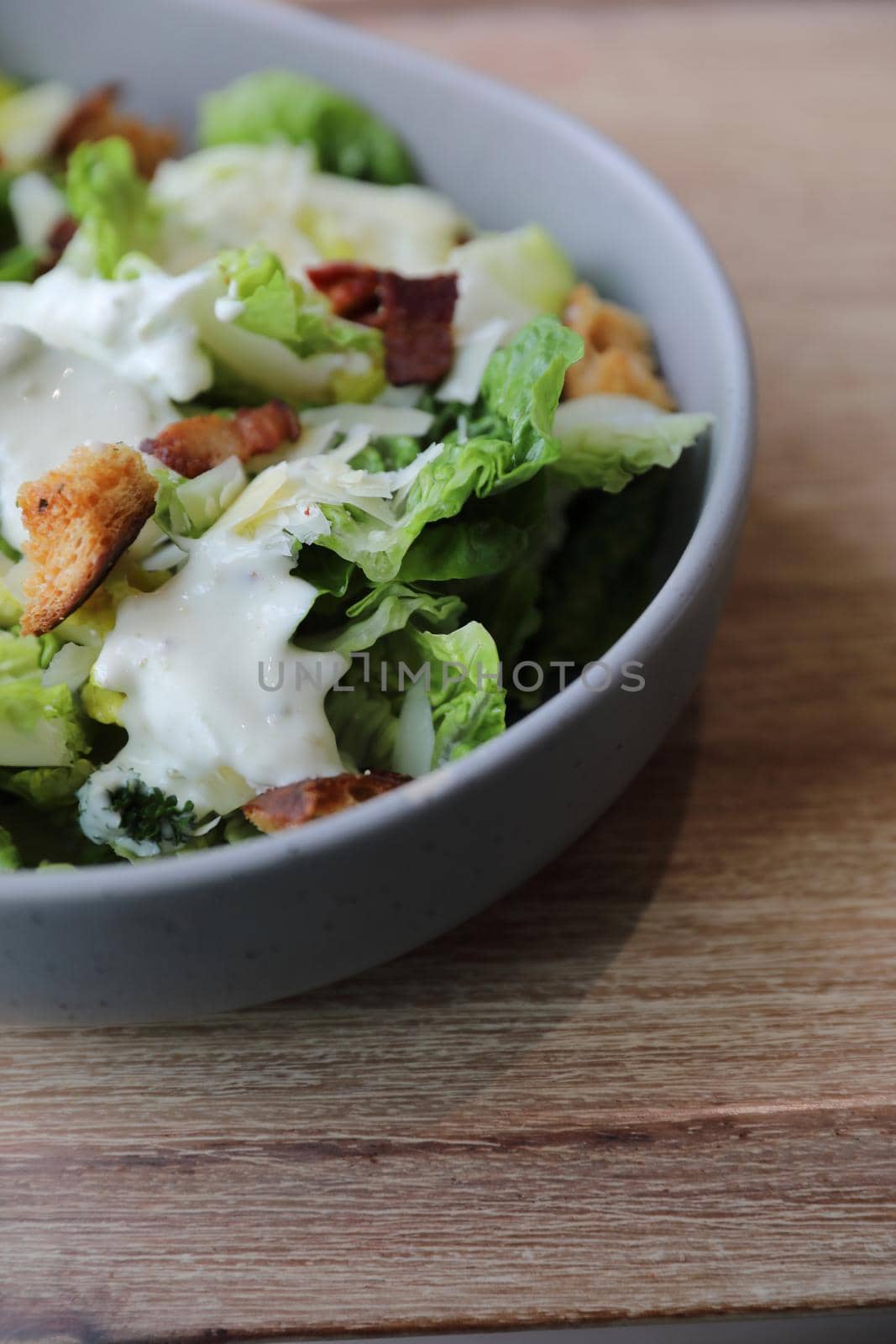 caesar salad appetizer on wooden background by piyato