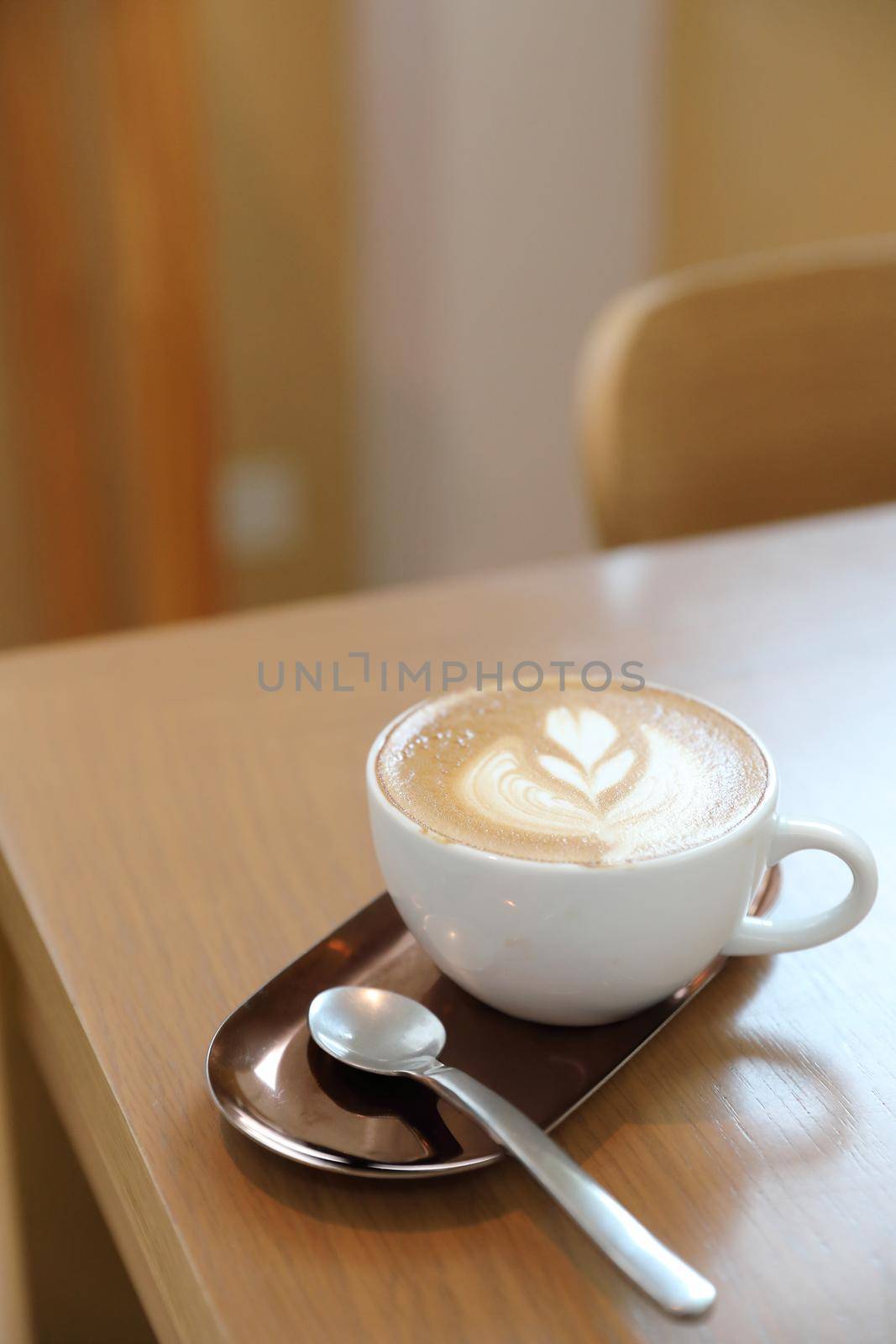 cappuccino or Latte art coffee made from milk on the wood table in coffee shop by piyato