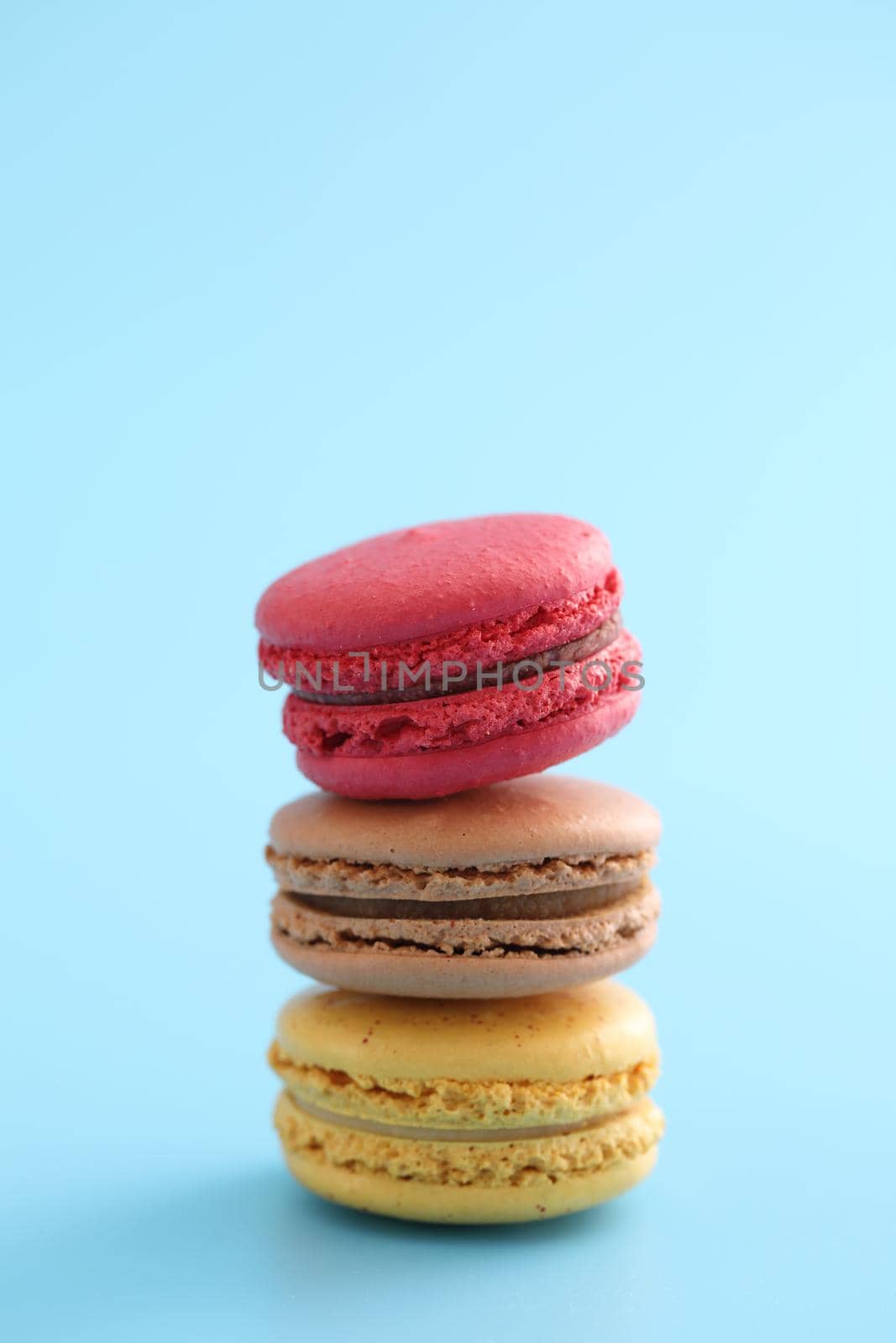 Colorful macarons isolated in blue background by piyato