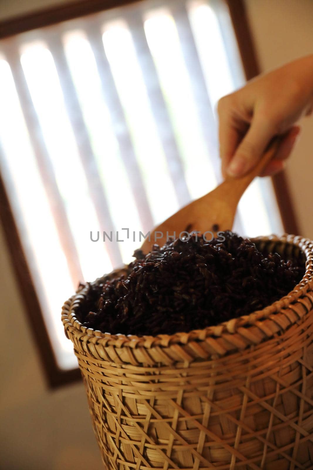 Boiled riceberry rice on wood basket with spoon in close up by piyato