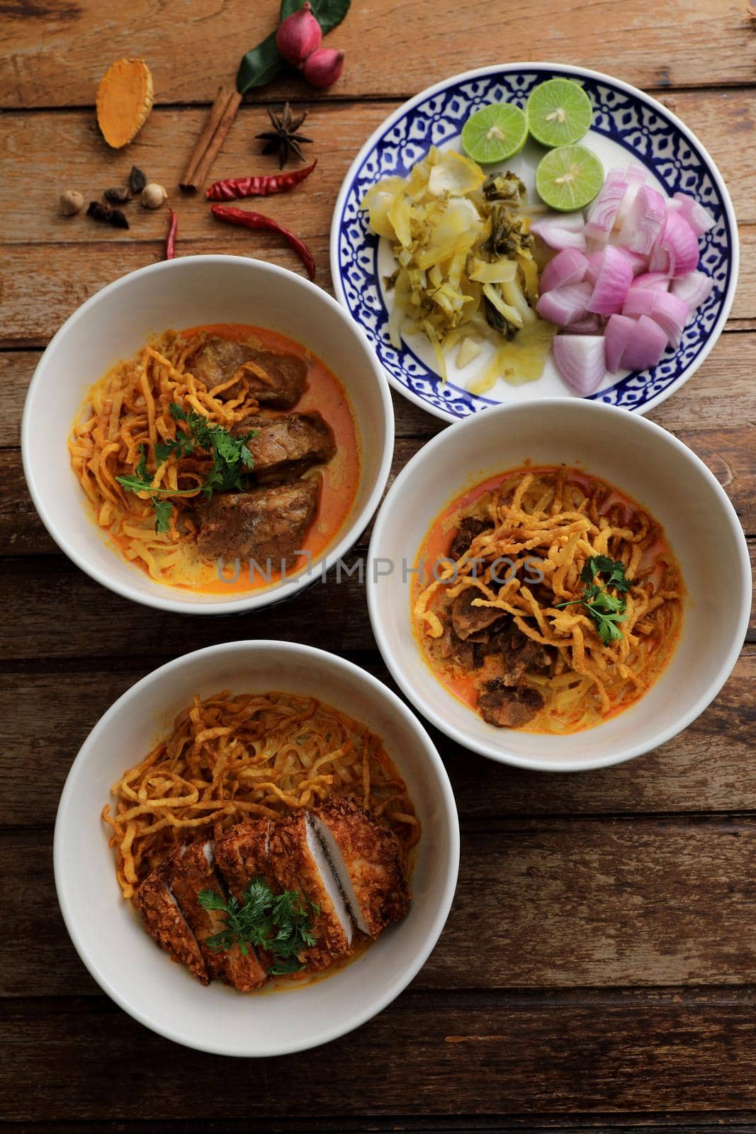 Local northern Thai food Egg noodle curry with pork and beef on wood background