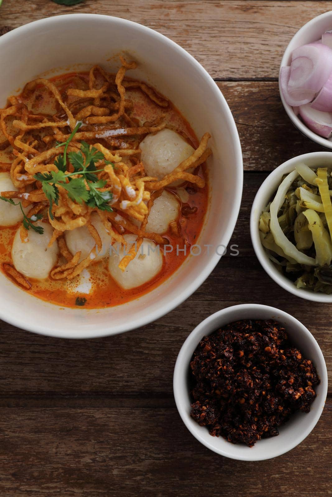 Local northern Thai food Egg noodle curry with meatballs on wood background by piyato