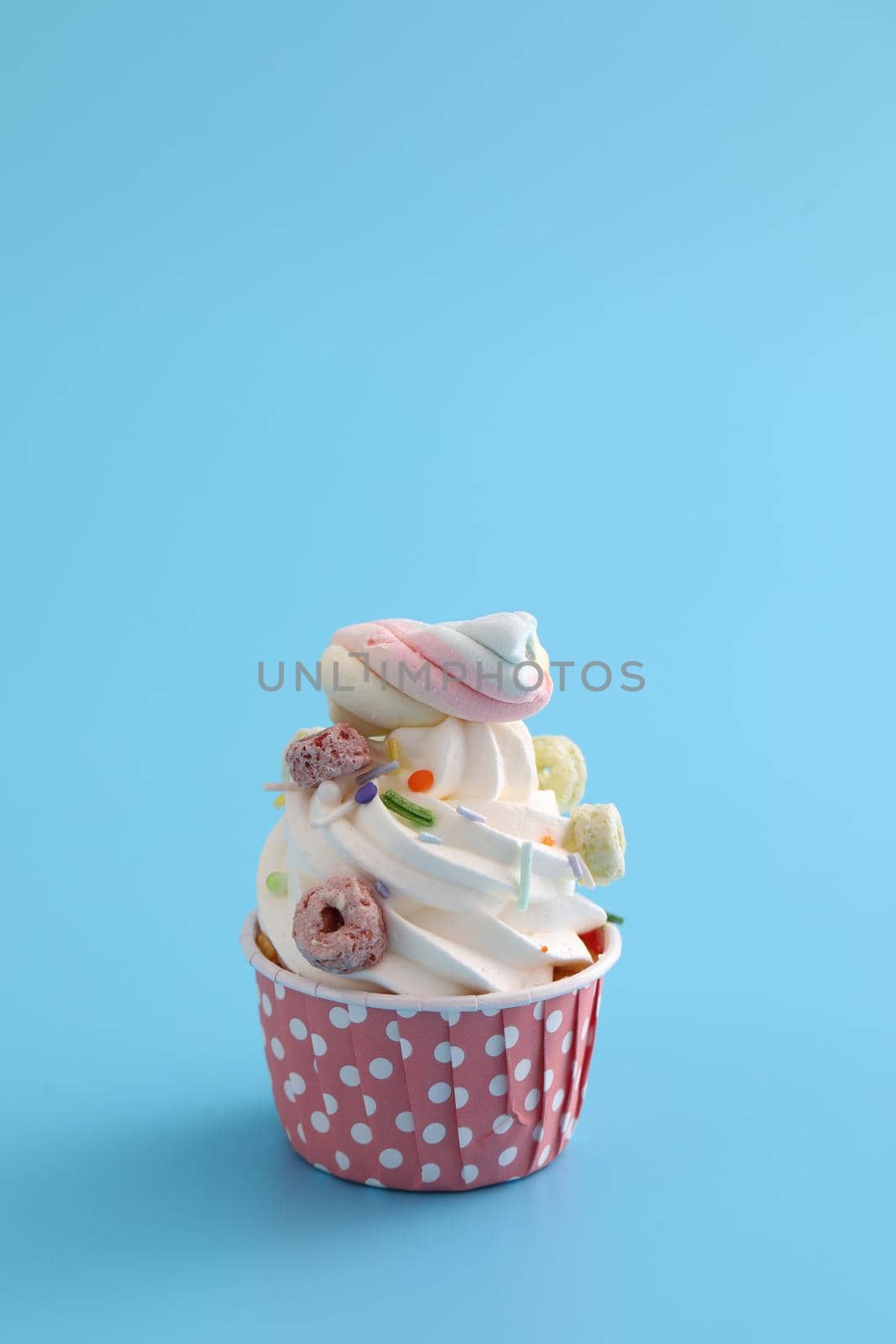 Colorful cupcake isolated in blue background by piyato