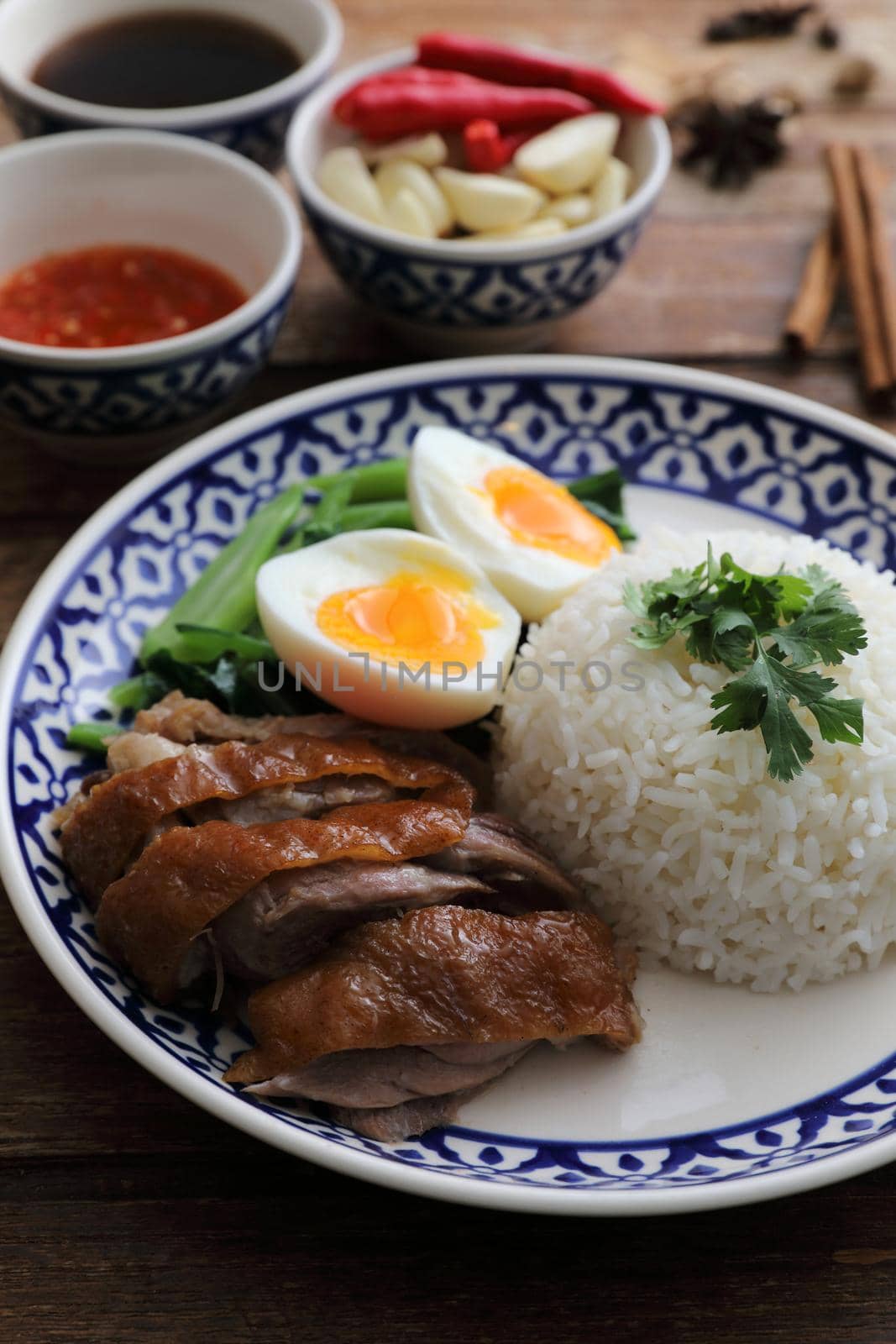 Local Thai food stewed pork leg on rice isolated in wood background by piyato