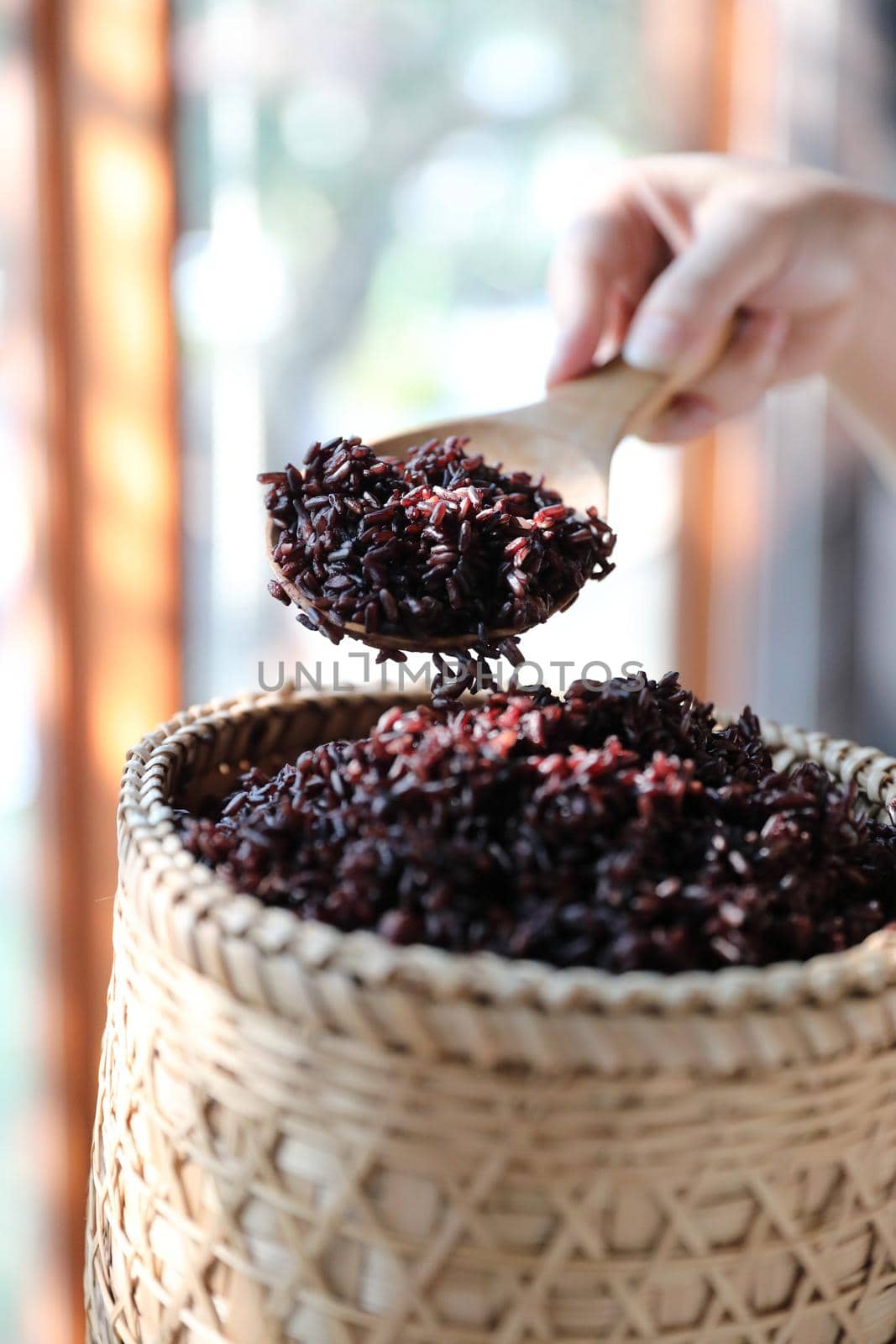 Boiled riceberry rice on wood basket with spoon in close up by piyato