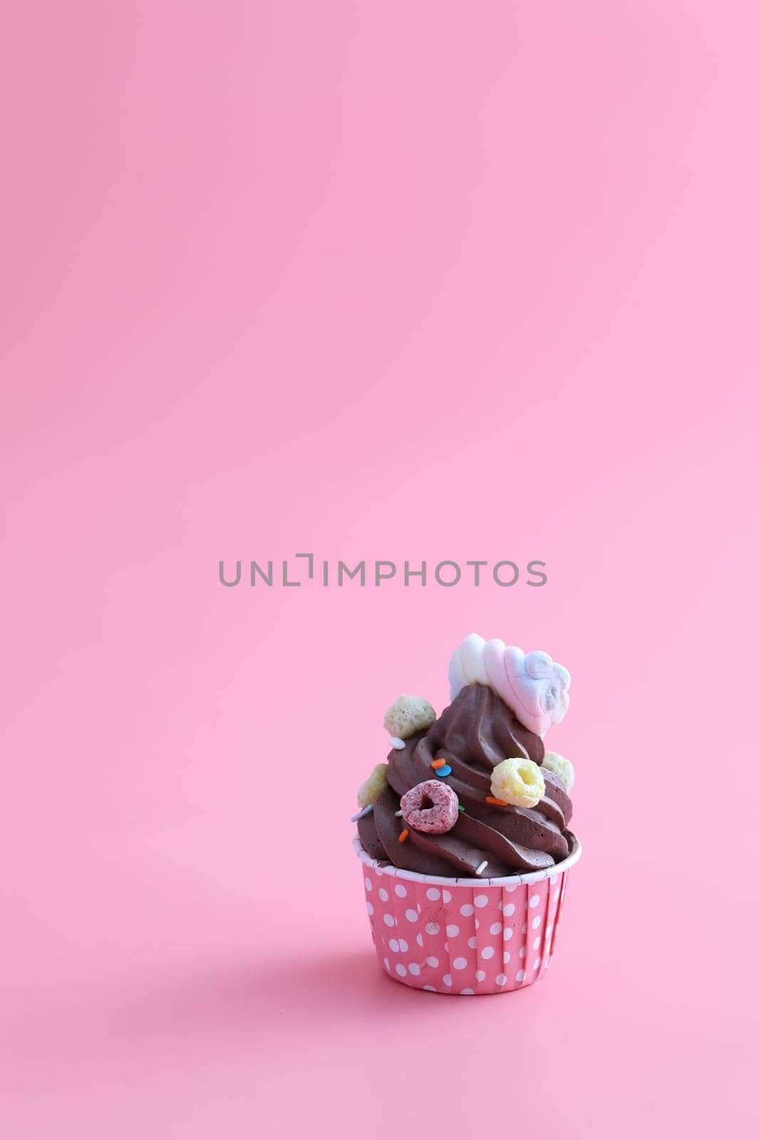 Chocolate cupcake isolated in pink background by piyato