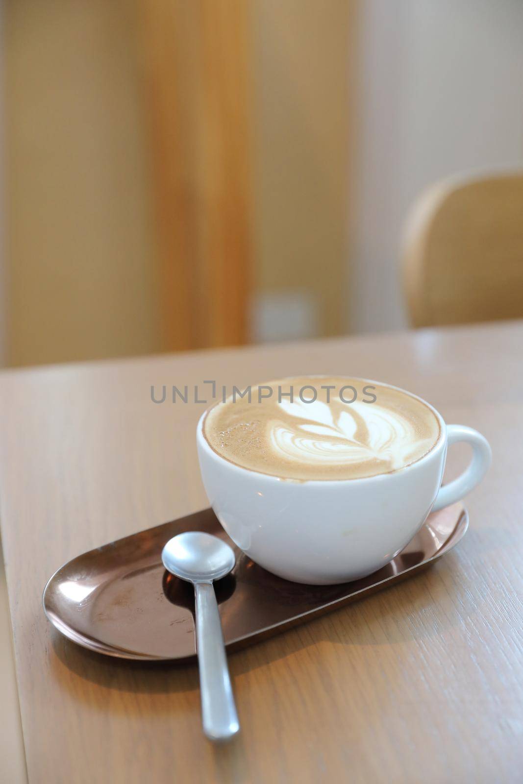 cappuccino or Latte art coffee made from milk on the wood table in coffee shop by piyato