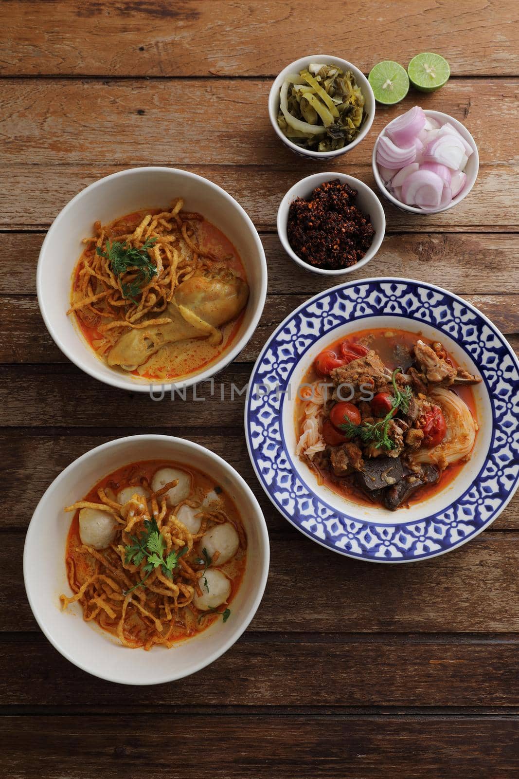 Local northern Thai food Egg noodle curry with chicken and meatball and Rice noodles on wood background by piyato