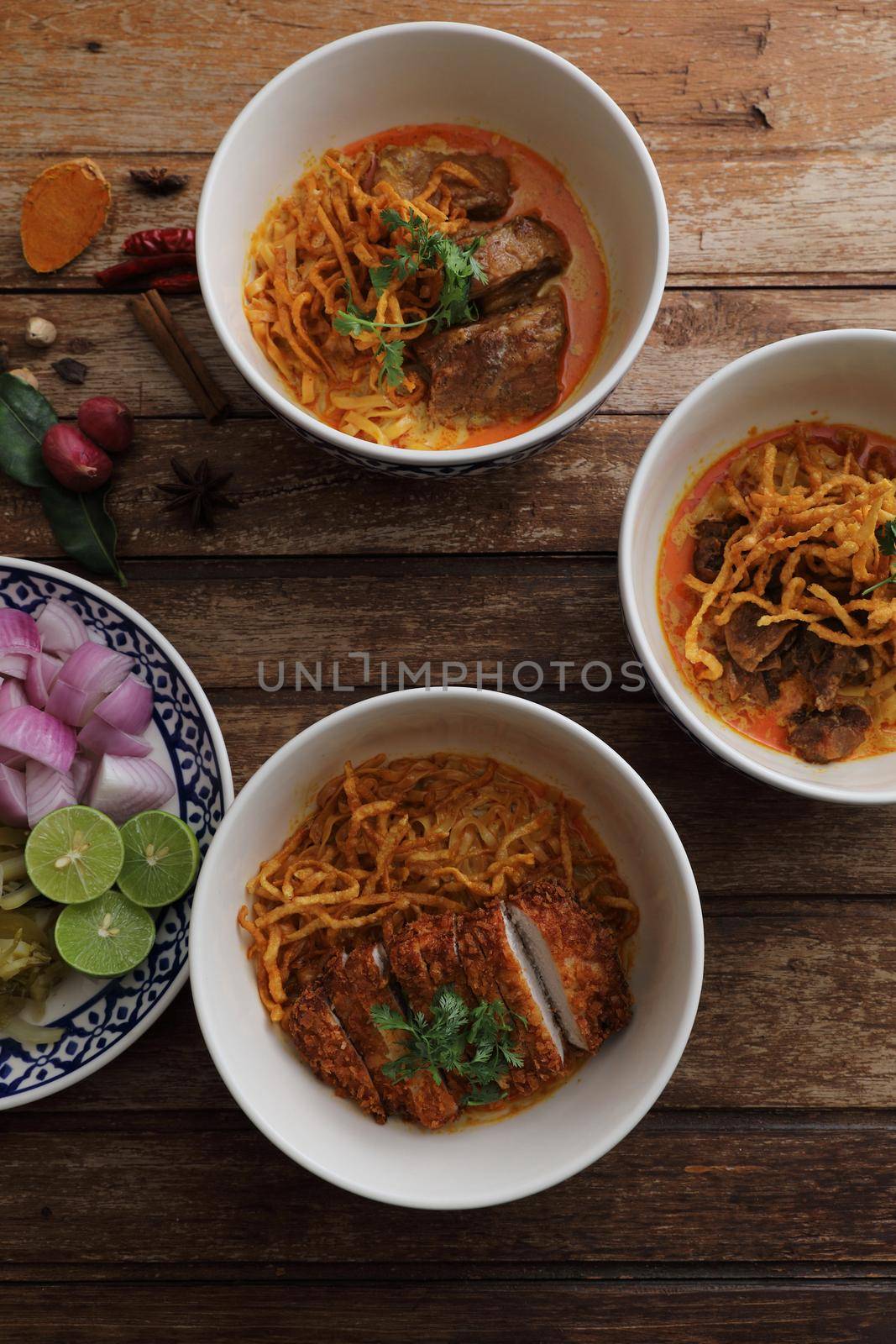 Local northern Thai food Egg noodle curry with pork and beef on wood background