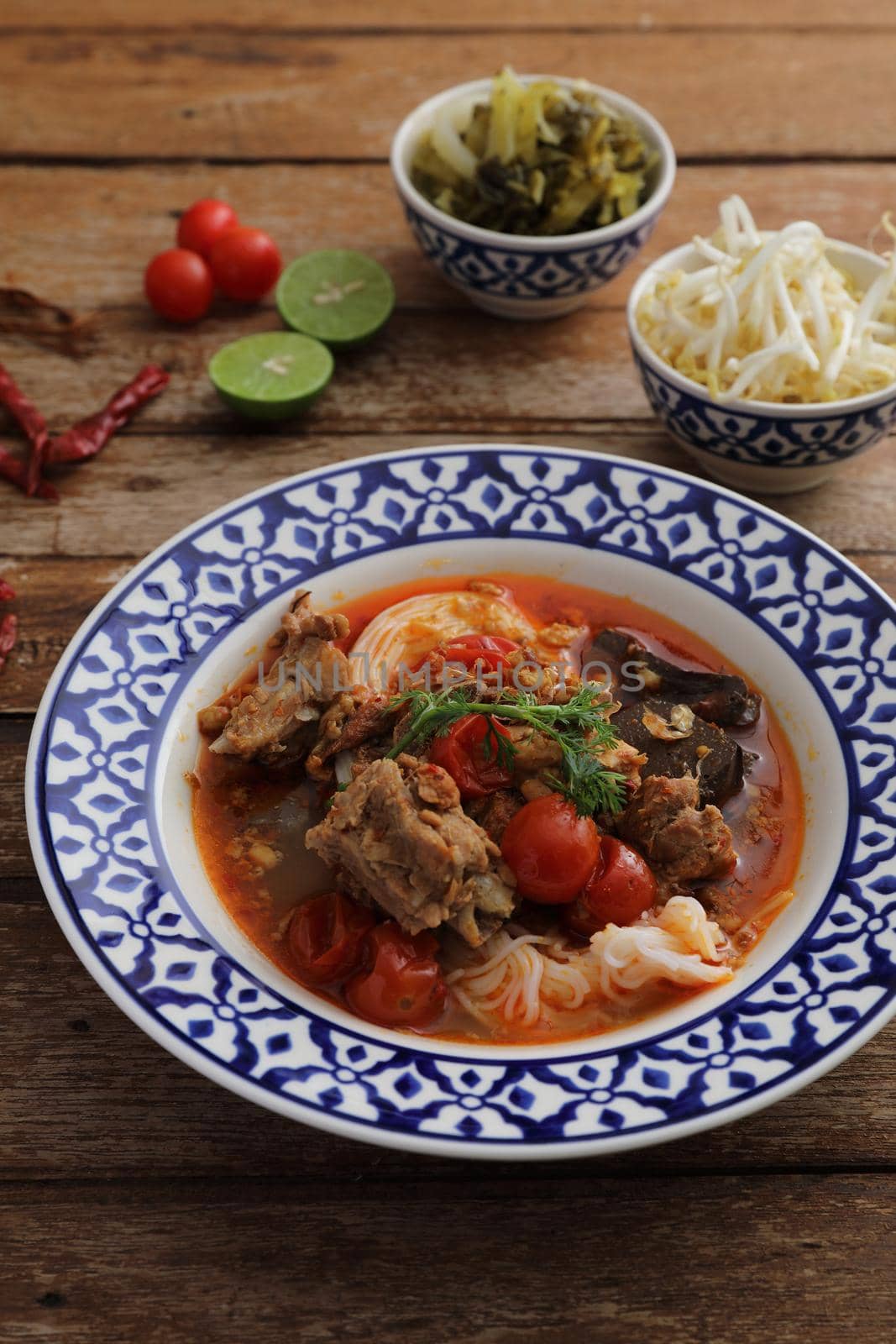 Local northern thai food Rice noodles with pork in spicy soup in wood background by piyato