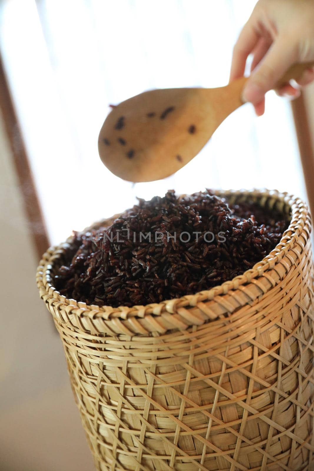 Boiled riceberry rice on wood basket with spoon in close up by piyato