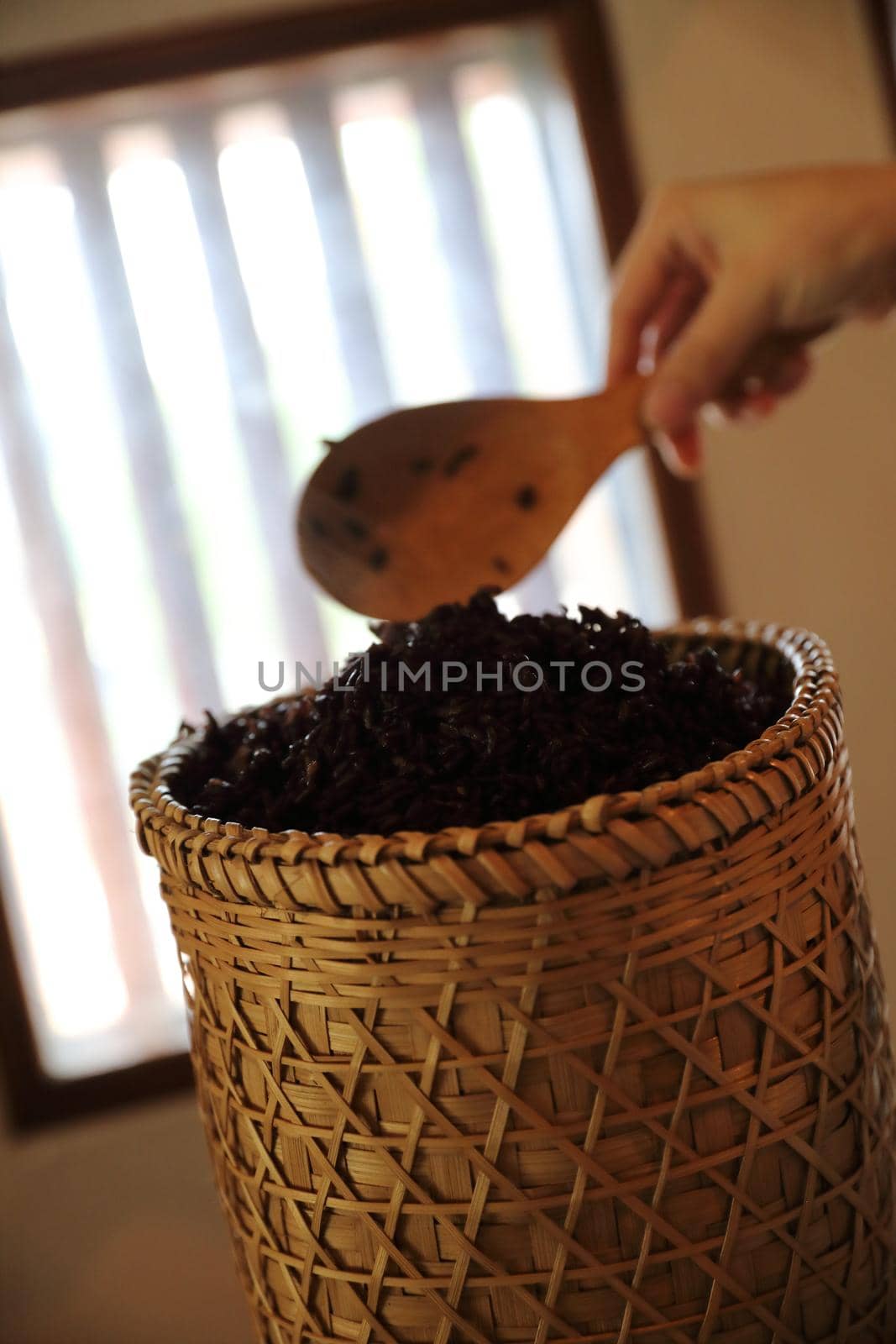 Boiled riceberry rice on wood basket with spoon in close up by piyato