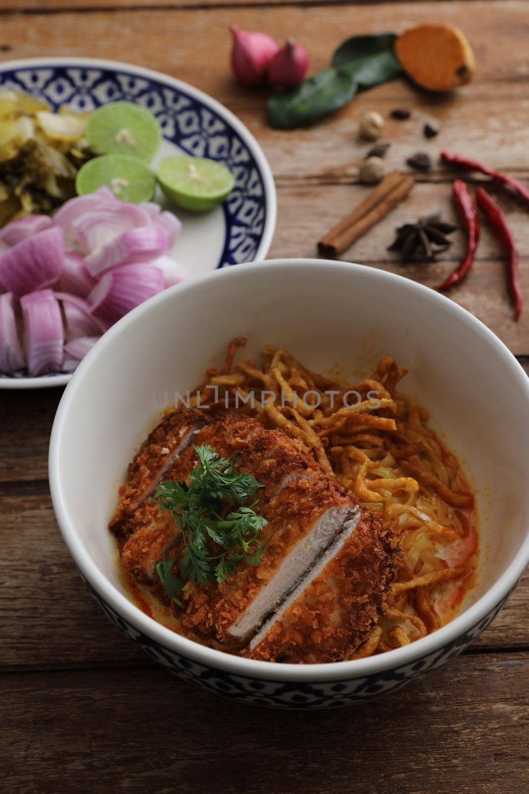 Local northern Thai food Egg noodle curry with fried pork on wood background