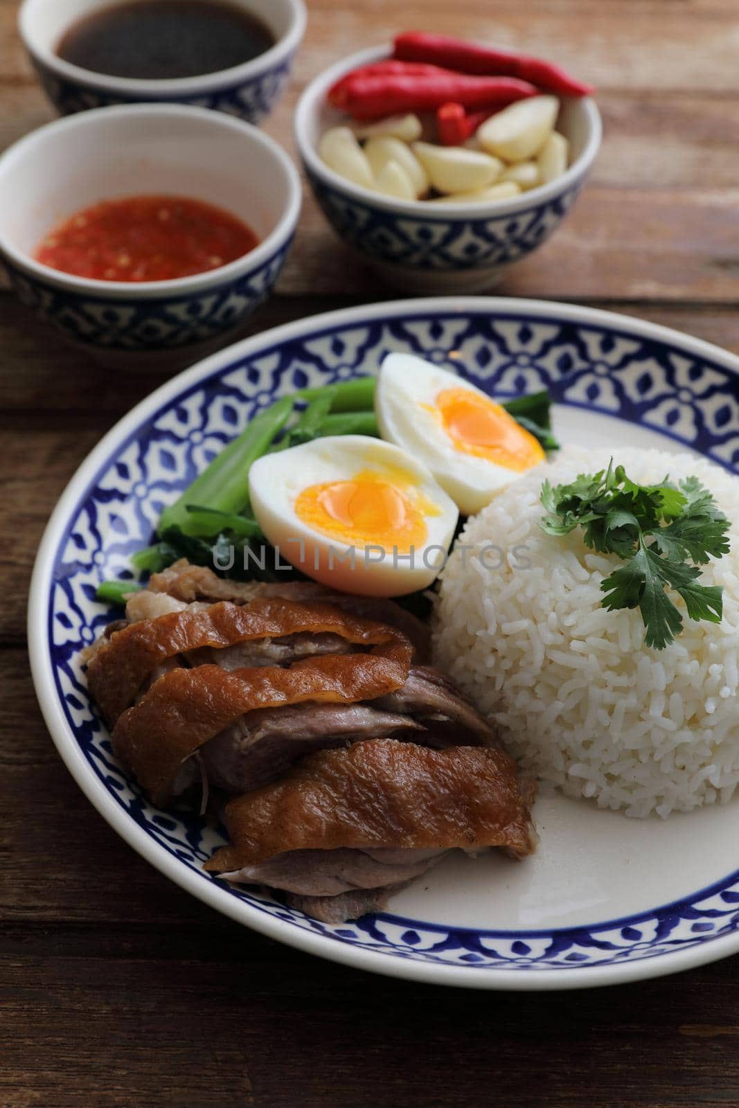 Local Thai food stewed pork leg on rice isolated in wood background by piyato