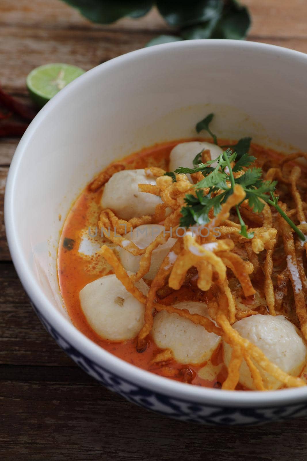 Local northern Thai food Egg noodle curry with meatballs on wood background