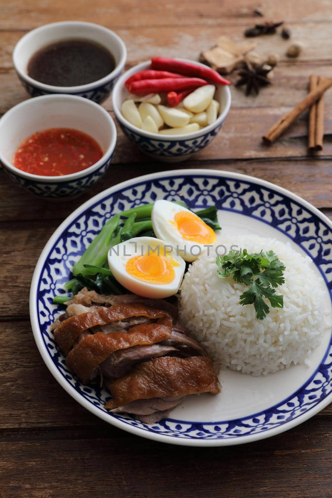 Local Thai food stewed pork leg on rice isolated in wood background
