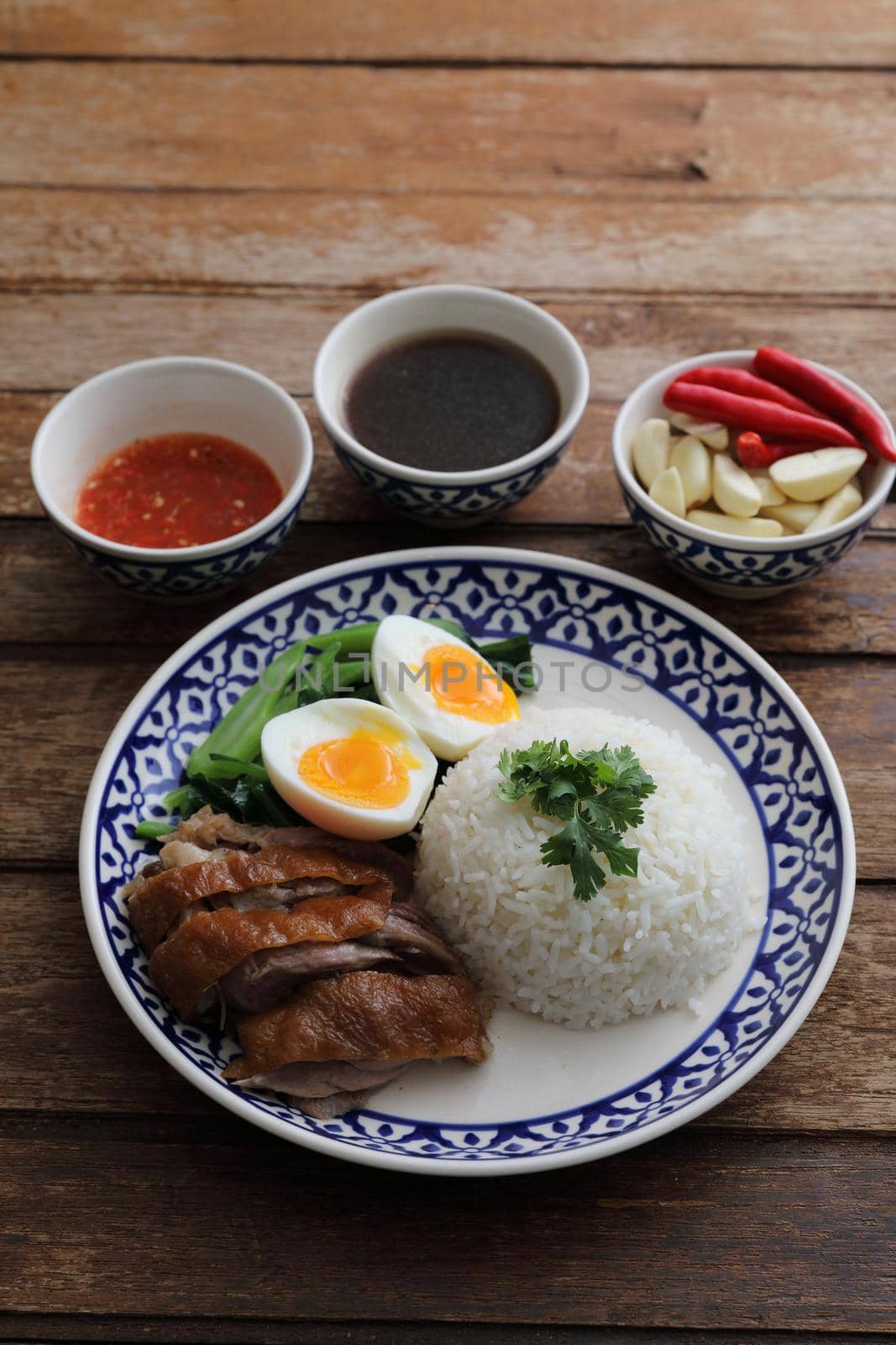 Local Thai food stewed pork leg on rice isolated in wood background by piyato