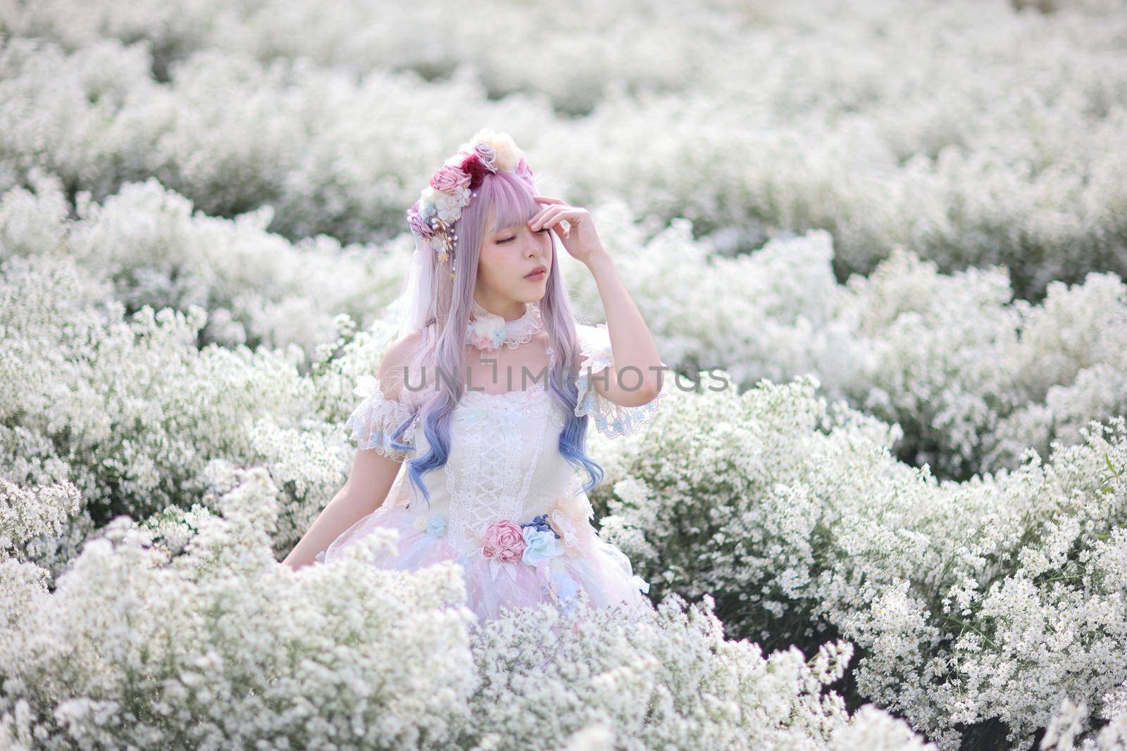 Beautiful young woman with white lolita dress with flowers garden Japanese fashion