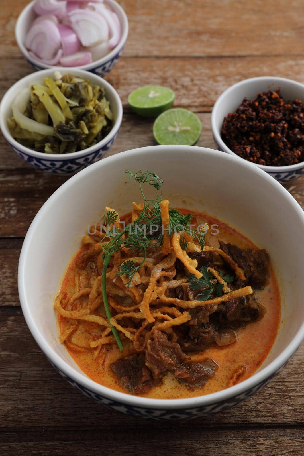 Local northern Thai food Egg noodle curry with beef on wood background by piyato