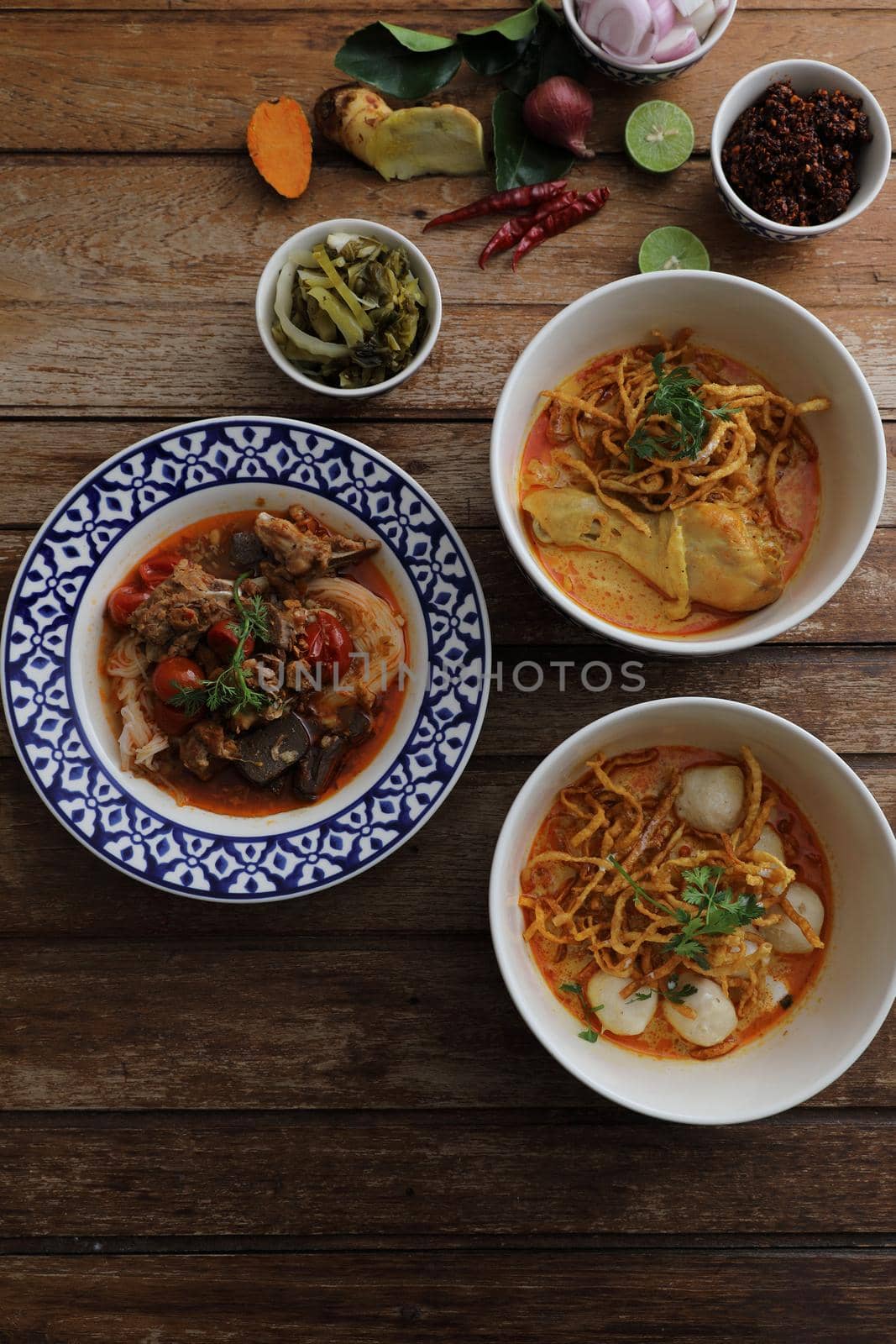 Local northern Thai food Egg noodle curry with chicken and meatball and Rice noodles on wood background by piyato