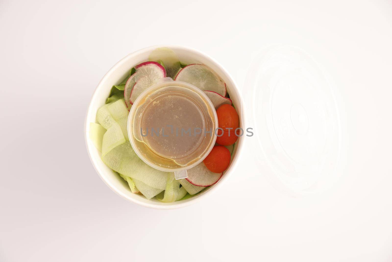 Salad in plastic package for take away or food delivery isolated on white background
