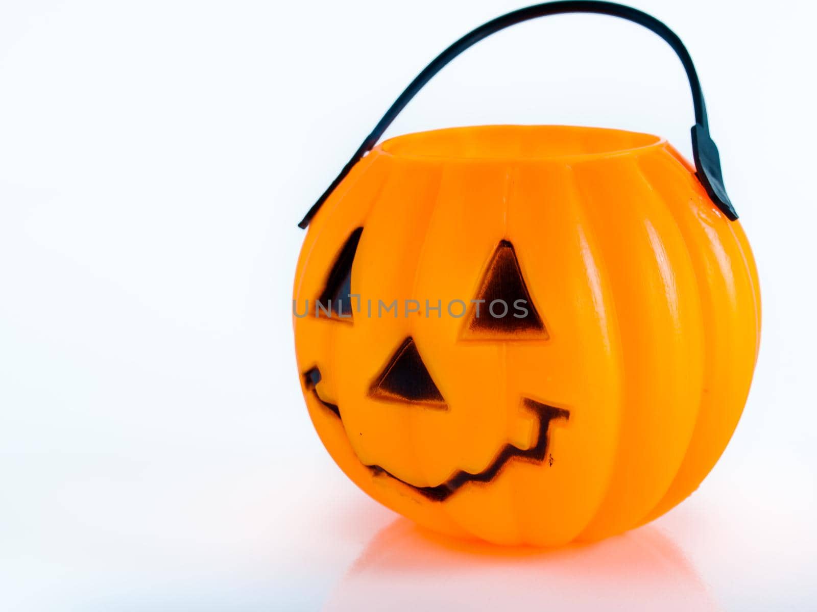 Halloween bag in shape of Jack-o'-lantern on white background.