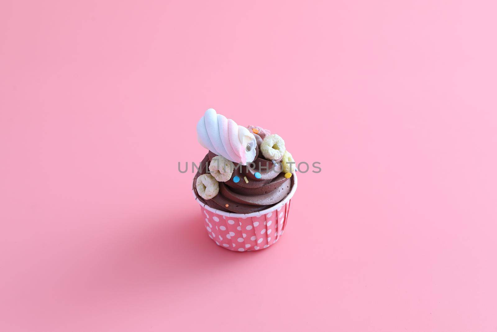 Chocolate cupcake isolated in pink background by piyato
