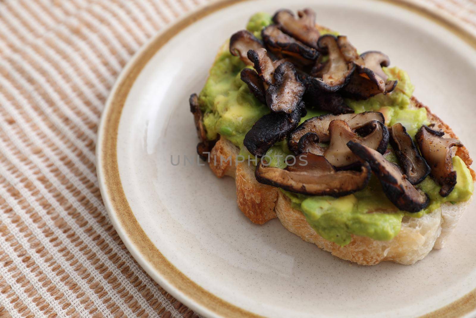 Toast with avocado and grilled mushroom in white background by piyato