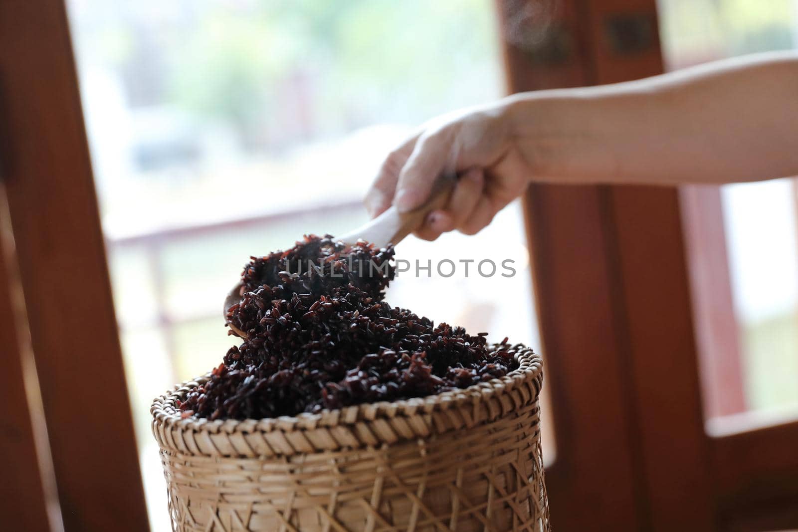 Boiled riceberry rice on Wicker basket with spoon in close up