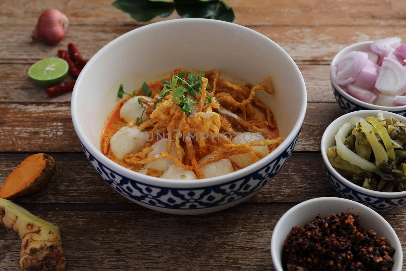 Local northern Thai food Egg noodle curry with meatballs on wood background