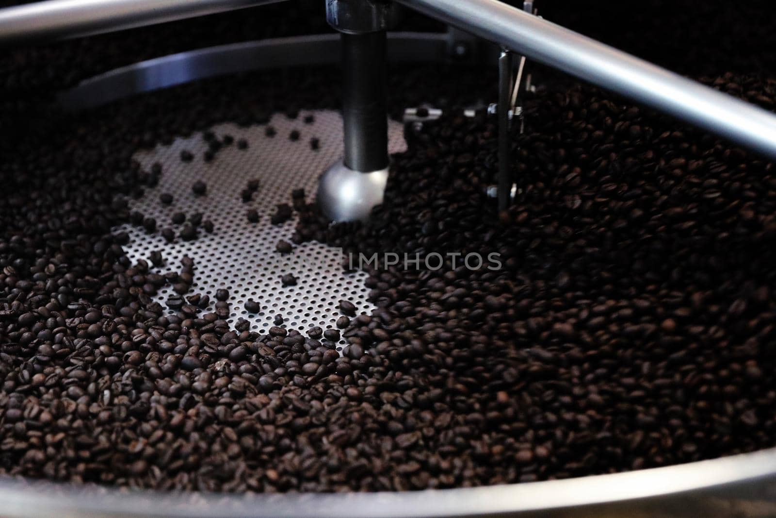 Coffee beans roasting with machine in close up