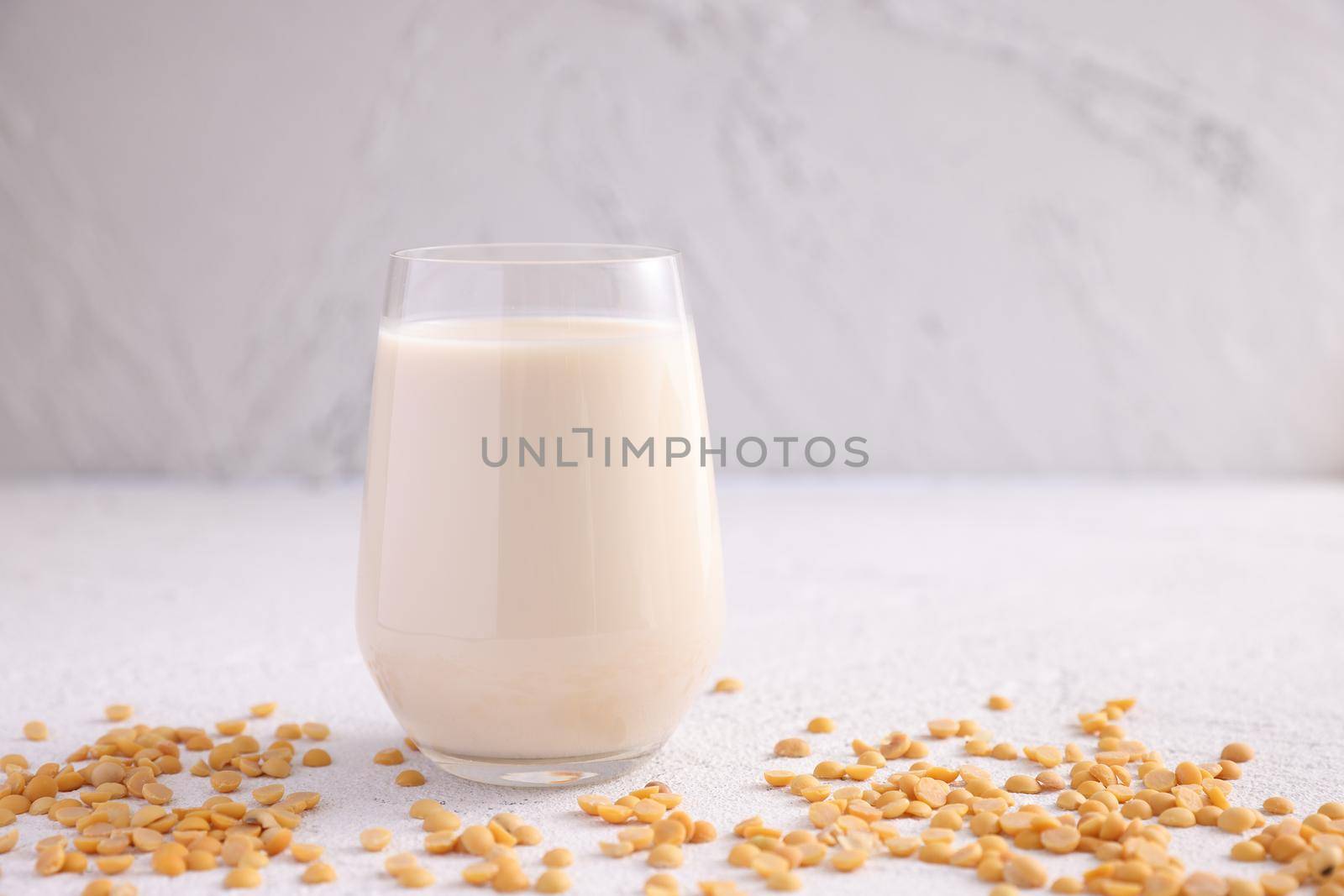 Soy milk in glass and soy bean isolated in white background by piyato