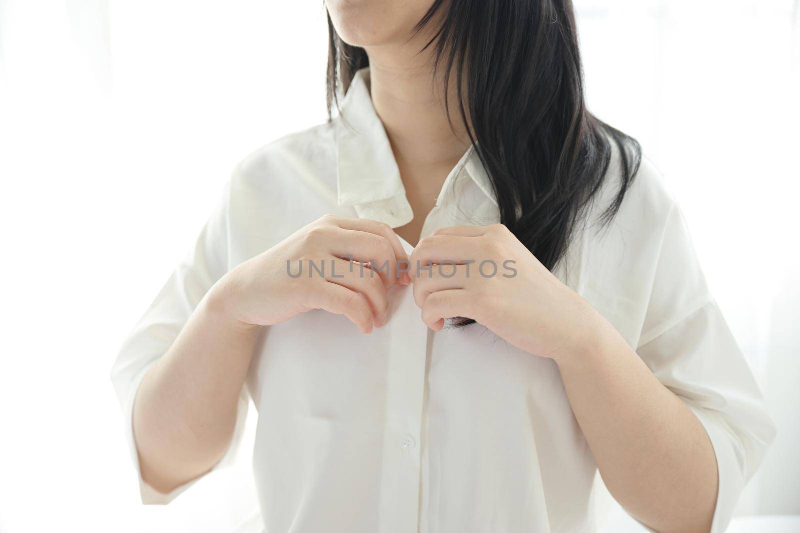 Beautiful young woman waking up in the morning at white bedroom