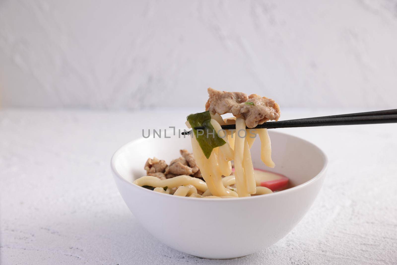 Udon noodles with pork isolated in white background by piyato
