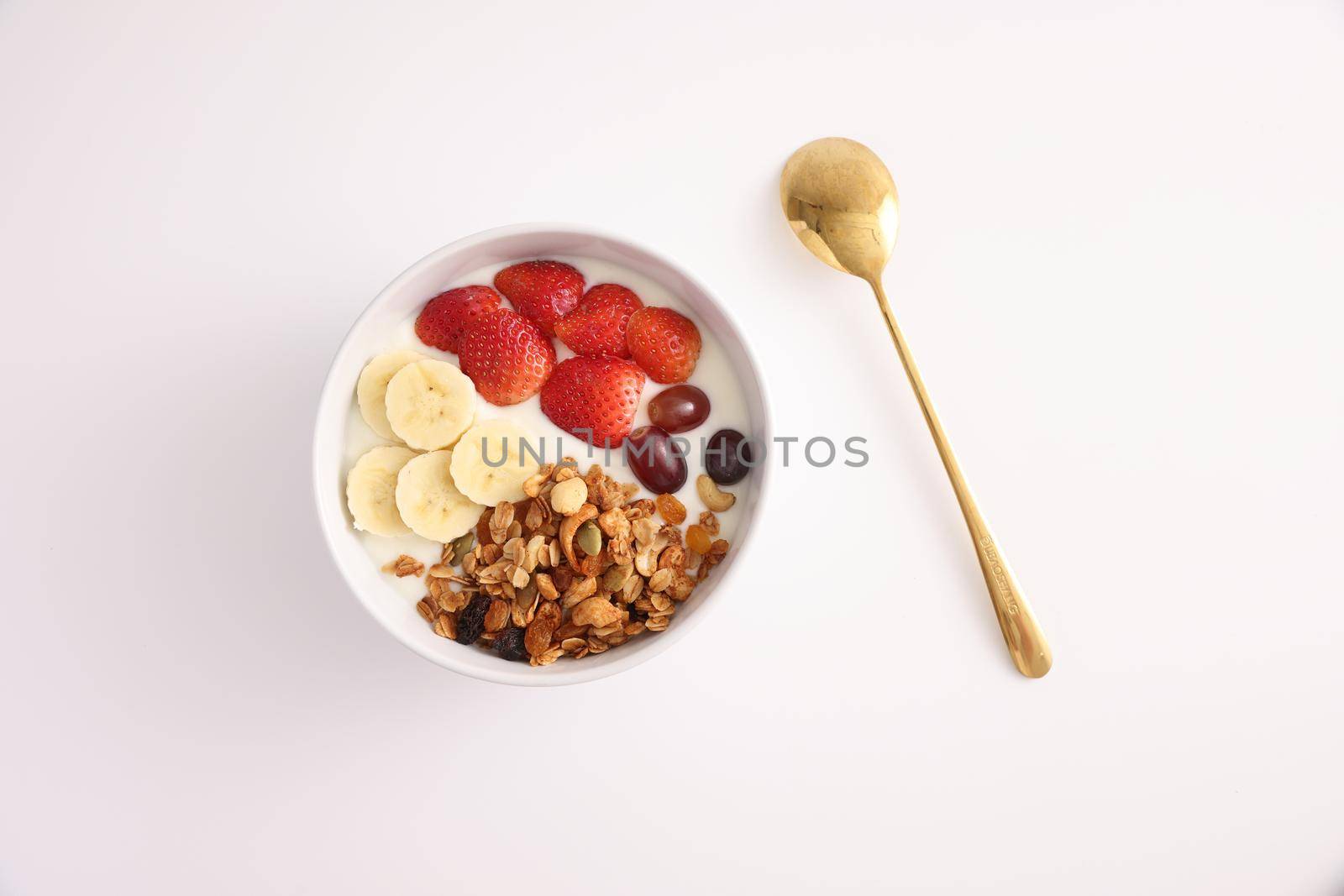 bowl of granola cereal with yogurt and berries isolated on white background by piyato