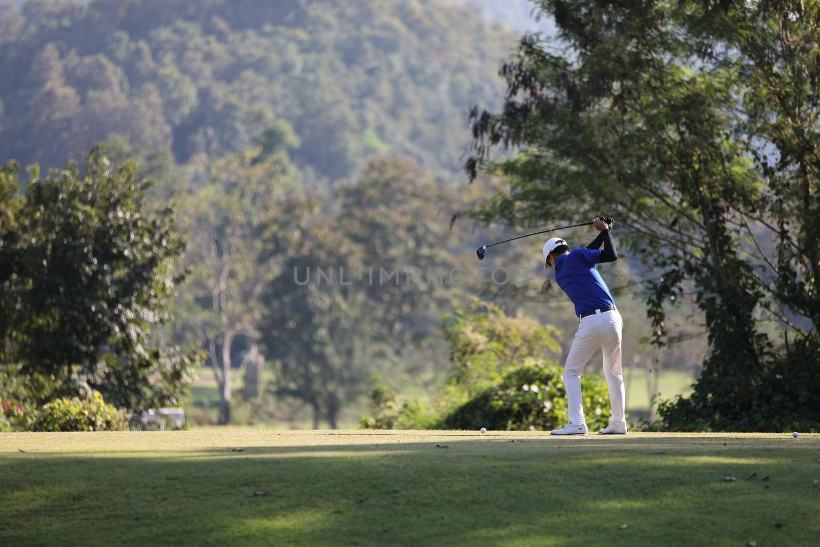 Young male golfer player on golf course by piyato