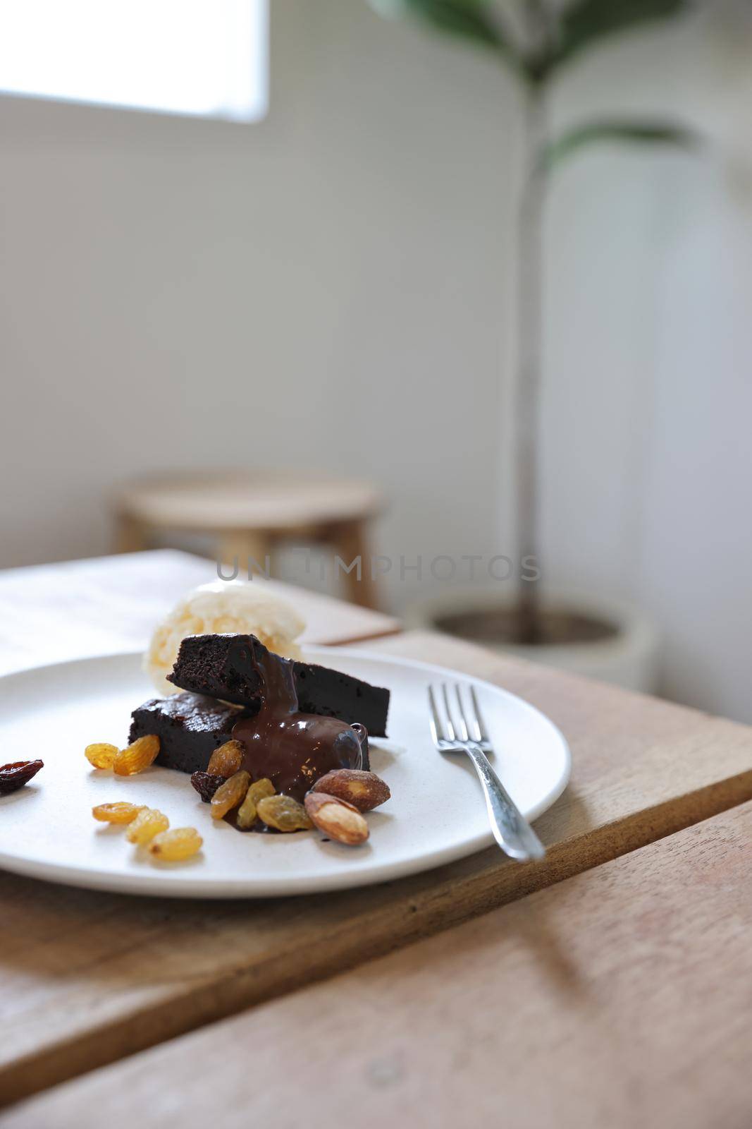 Brownies with dried fruits and ice cream on wood background by piyato