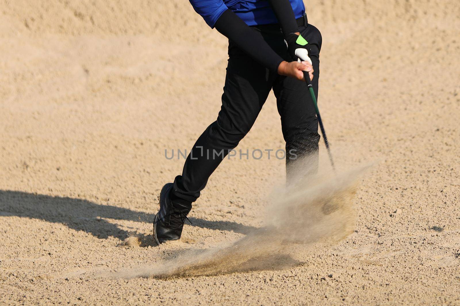 Young male golfer player on sand golf course by piyato