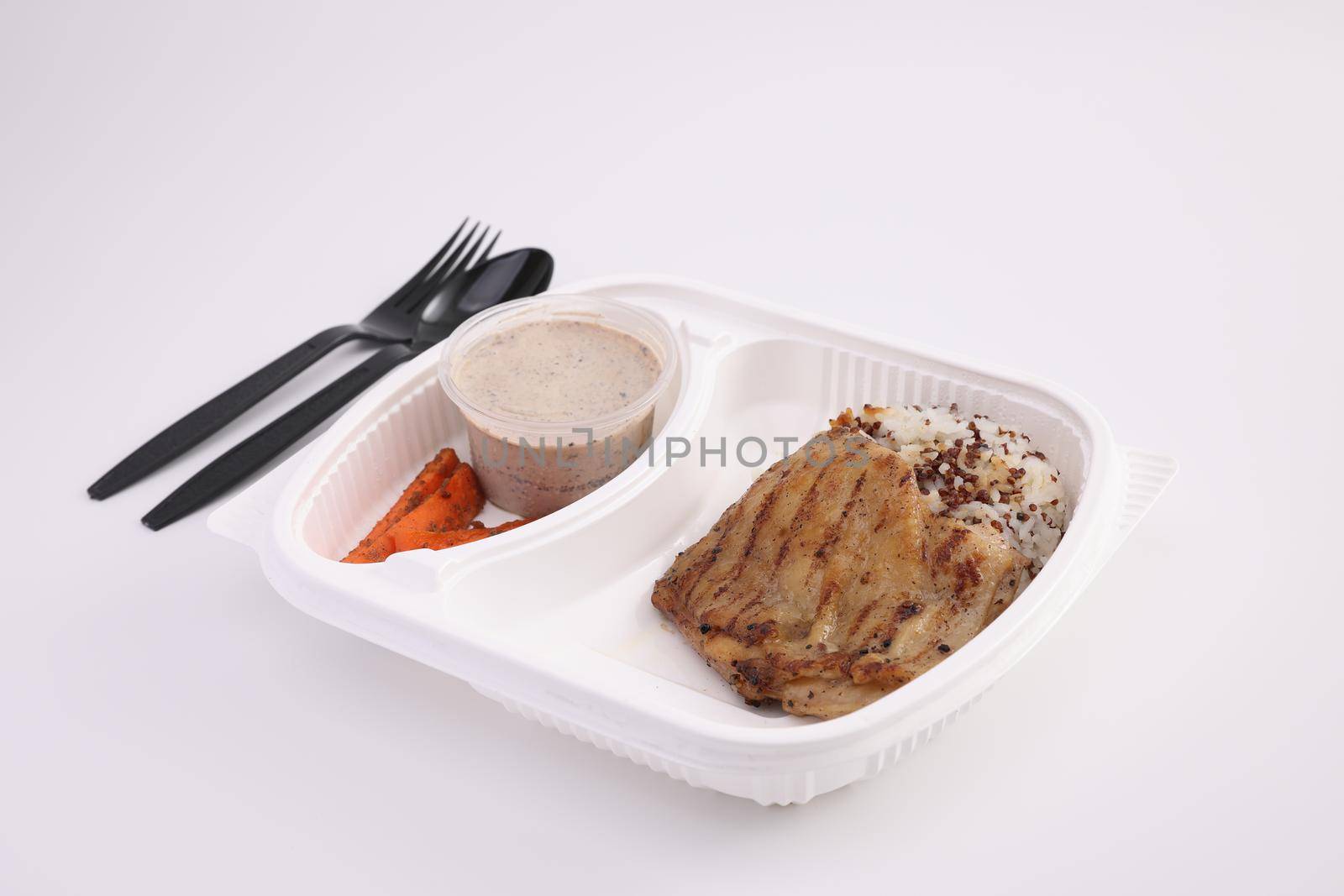 Grilled chicken with rice with delivery package isolated in white background by piyato