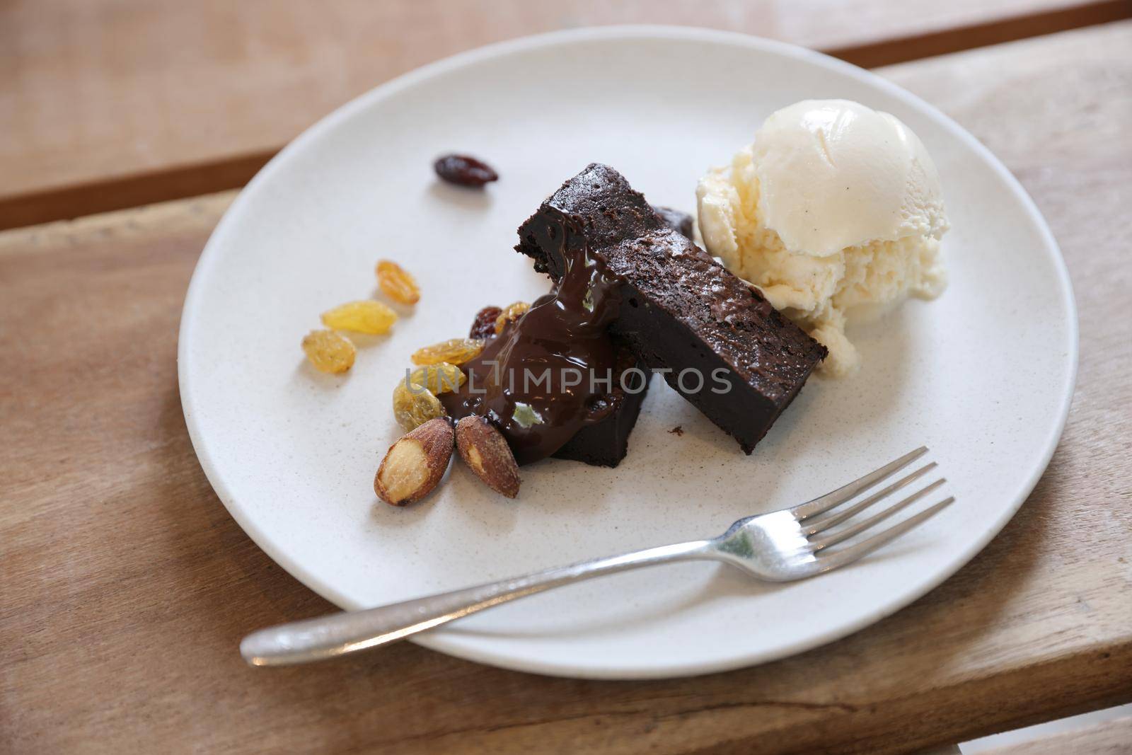 Brownies with dried fruits and ice cream on wood background by piyato