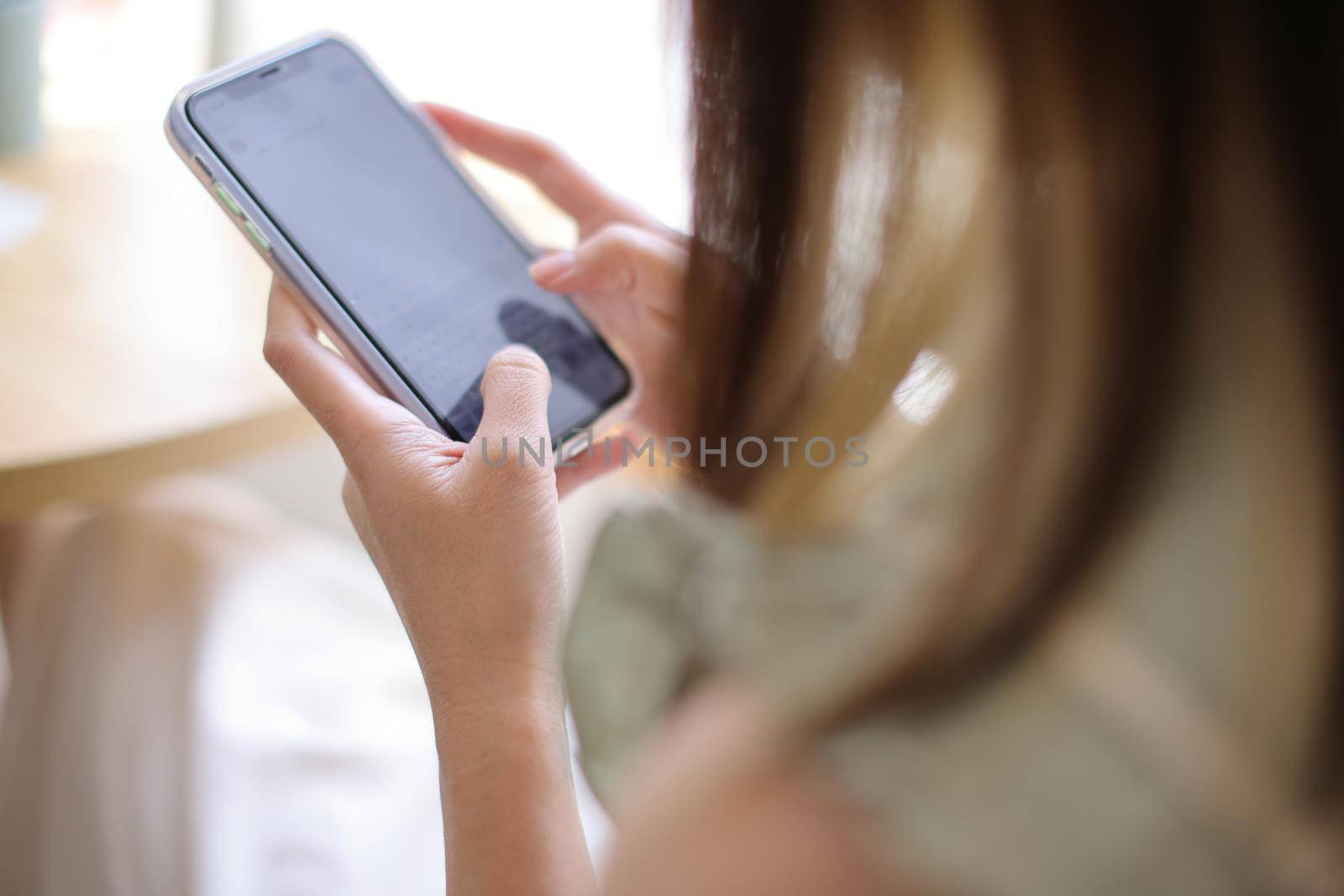 Woman hand using a smartphone for Stock exchange trading online in the coffee shop, business concept