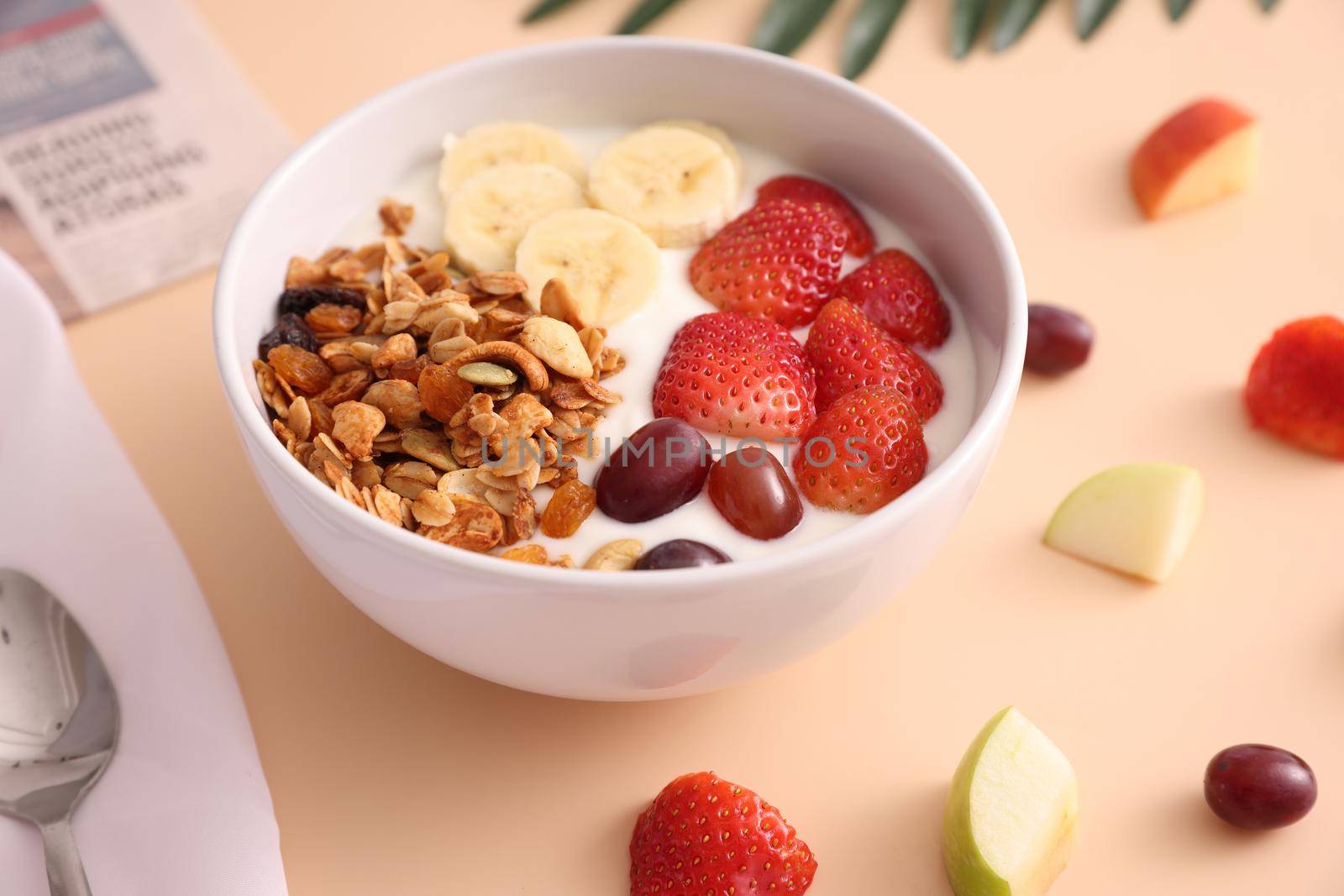 bowl of granola cereal with yogurt and berries isolated on eggnog color background by piyato