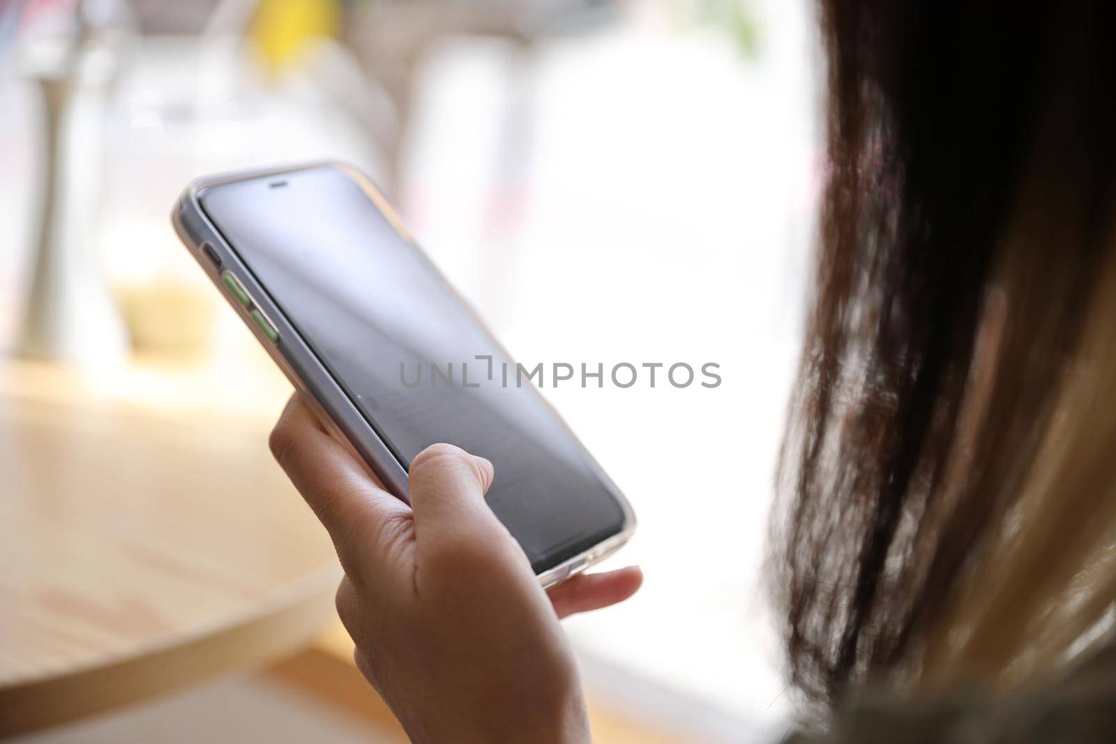 Woman hand using a smartphone for Stock exchange trading online in the coffee shop, business concept