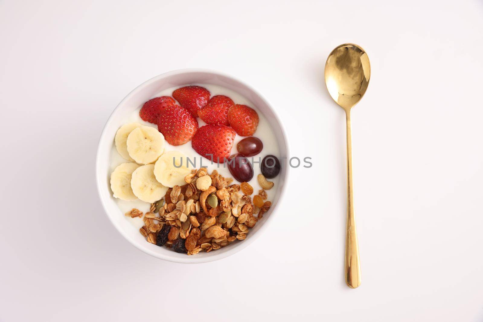 bowl of granola cereal with yogurt and berries isolated on white background